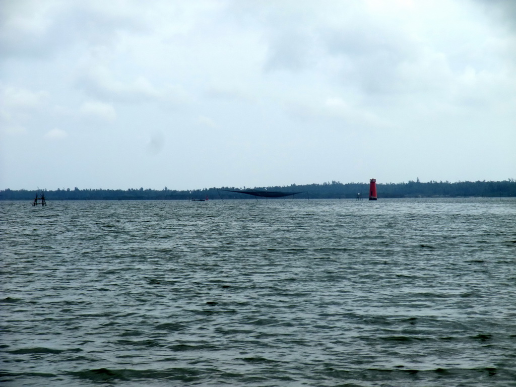 Fishing net and lighthouse at Bamenwan Bay, viewed from the tour boat