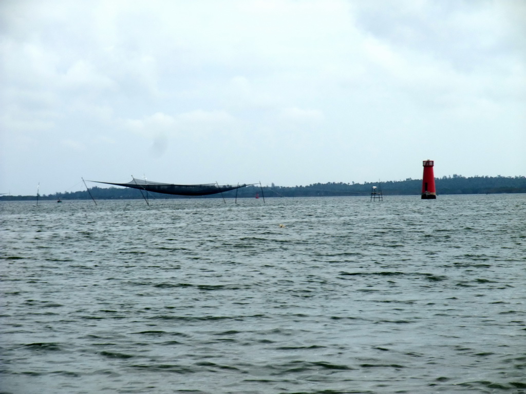 Fishing net and lighthouse at Bamenwan Bay, viewed from the tour boat