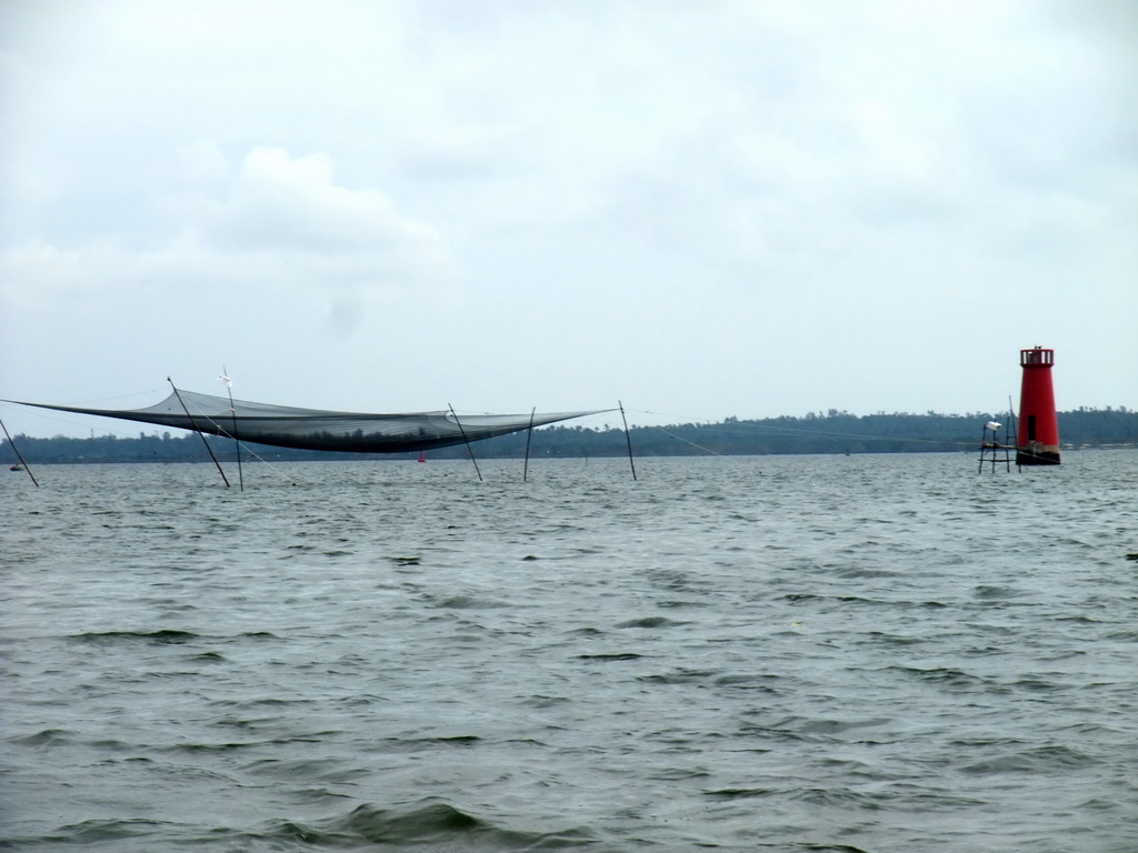 Fishing net and lighthouse at Bamenwan Bay, viewed from the tour boat