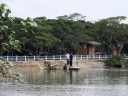 People with a fishnet near a restaurant at the Bamenwan Mangrove Forest