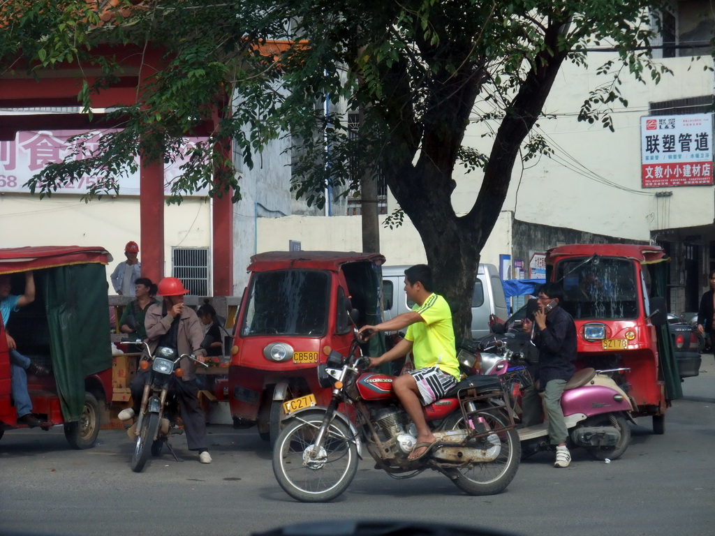 Motorcycles and rickshaws in the town of Wenchang