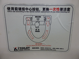 Chinglish sign on a toilet with rotating plastic layer on the seat, at Xiamen Gaoxi International Airport