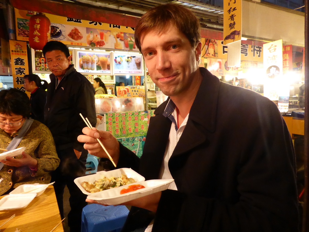Tim eating an oister omelet at a snack stall at the Taiwan Snack Street at Renhe Road