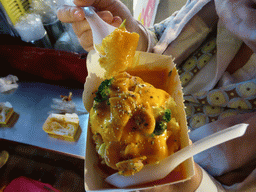 Miaomiao eating a potato snack at a snack stall at the Taiwan Snack Street at Renhe Road