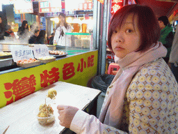 Miaomiao eating balls with filling at a snack stall at the Taiwan Snack Street at Renhe Road
