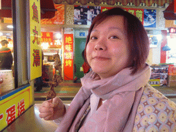 Miaomiao with a stick with meat at a snack stall at the Taiwan Snack Street at Renhe Road