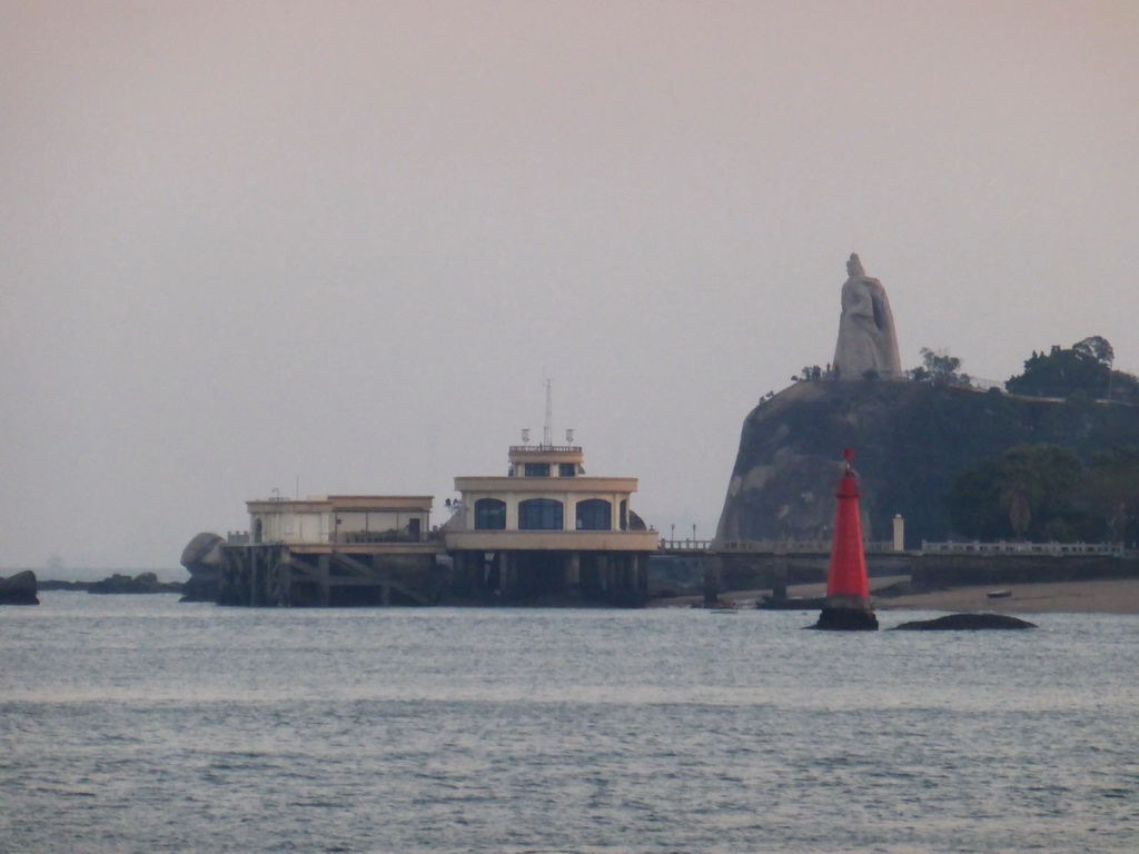 The large statue of Zheng Chenggong on Fuding Rock at the Haoyue Park and a pier with pavilion at Gulangyu Island, viewed from the ferry to Xiamen Island