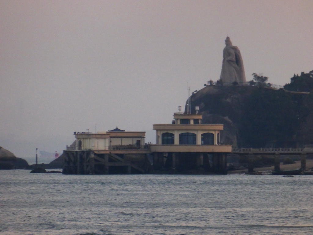 The large statue of Zheng Chenggong on Fuding Rock at the Haoyue Park and a pier with pavilion at Gulangyu Island, viewed from the ferry to Xiamen Island