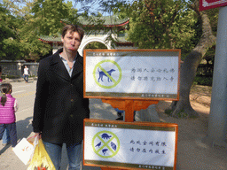 Tim with two signs at the entrance gate to the Nanputuo Temple