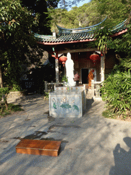 Statue, altar and monk in front of the Puzhao Temple at the back side of the Nanputuo Temple