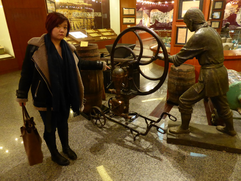 Miaomiao with a hand pump at the ChangYu Wine Culture Museum