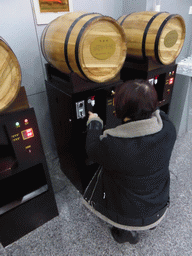 Miaomiao getting a cup of wine at a wine dispenser at the ChangYu Wine Culture Museum
