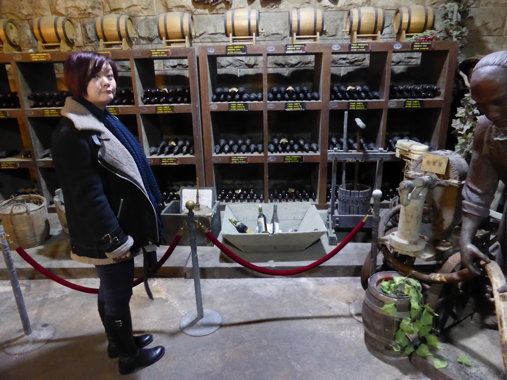 Miaomiao with wine bottles and barrels in the Underground Cellar at the ChangYu Wine Culture Museum