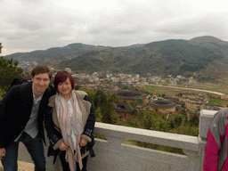 Tim and Miaomiao at the Yongding Scenic Area viewing point, with a view on the Qiaofu Lou, Chengqi Lou, Shize Lou and Beichen Lou buildings of the Gaobei Tulou Cluster