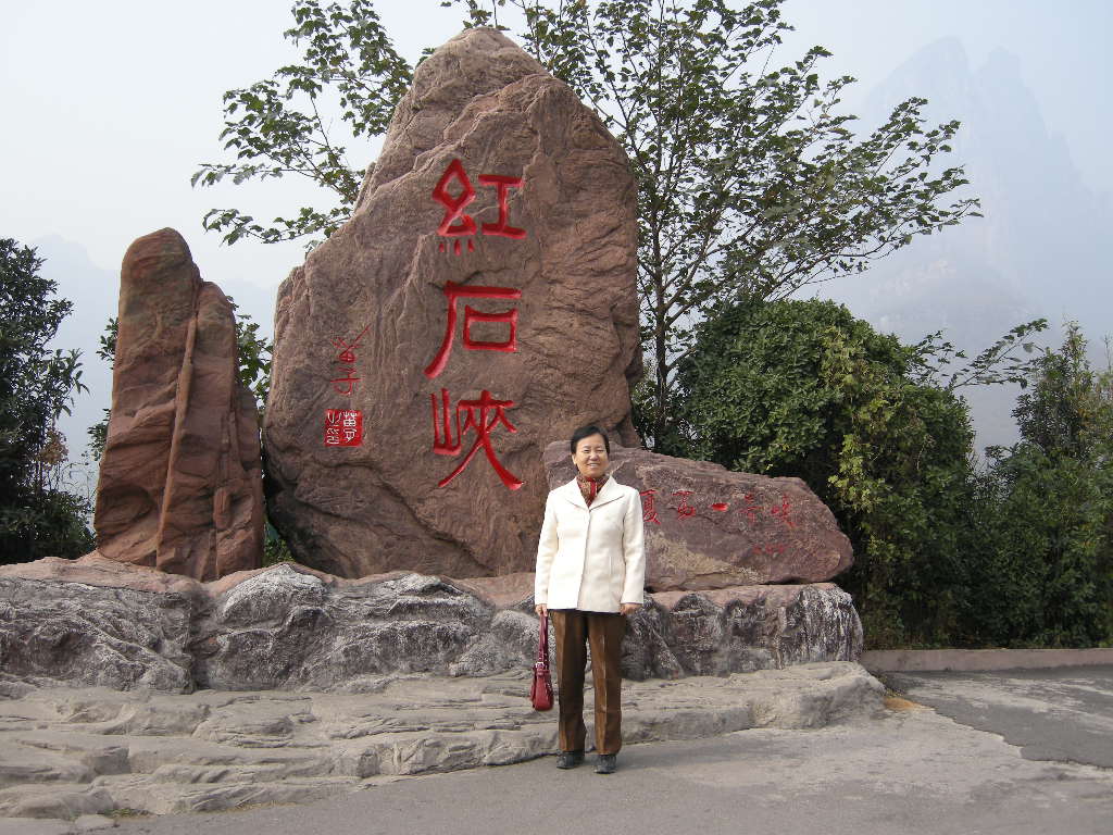 Miaomiao`s mother in front of a rock with inscription at the Mount Yuntaishan Global Geopark