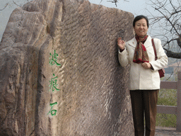 Miaomiao`s mother in front of a rock with inscription at the Mount Yuntaishan Global Geopark
