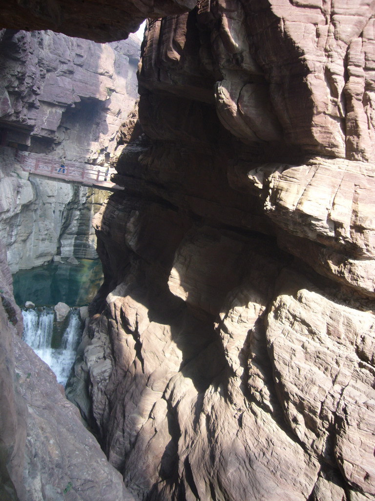 River, waterfall and bridge at the Red Stone Gorge at the Mount Yuntaishan Global Geopark, viewed from the mountainside path