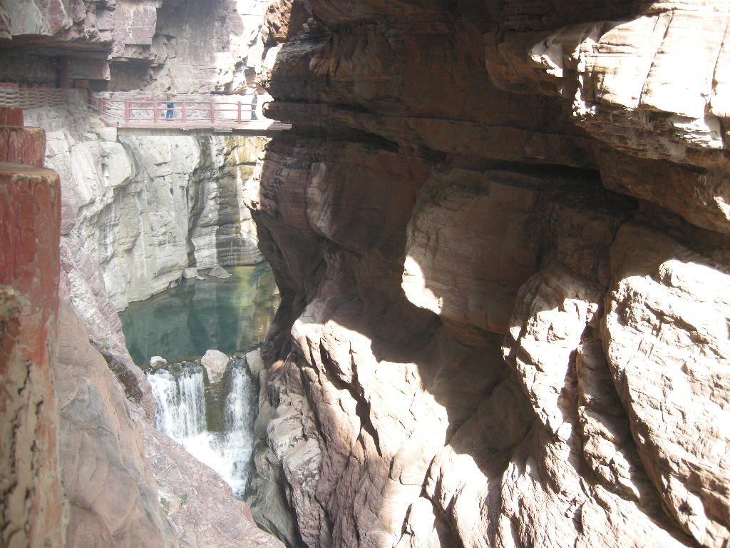 River, waterfall and bridge at the Red Stone Gorge at the Mount Yuntaishan Global Geopark, viewed from the mountainside path