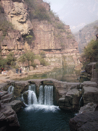 River and bridge over the waterfall at the Red Stone Gorge at the Mount Yuntaishan Global Geopark, viewed from the mountainside path