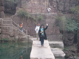 Miaomiao`s aunt at the bridge over the waterfall at the Red Stone Gorge at the Mount Yuntaishan Global Geopark, viewed from the mountainside path