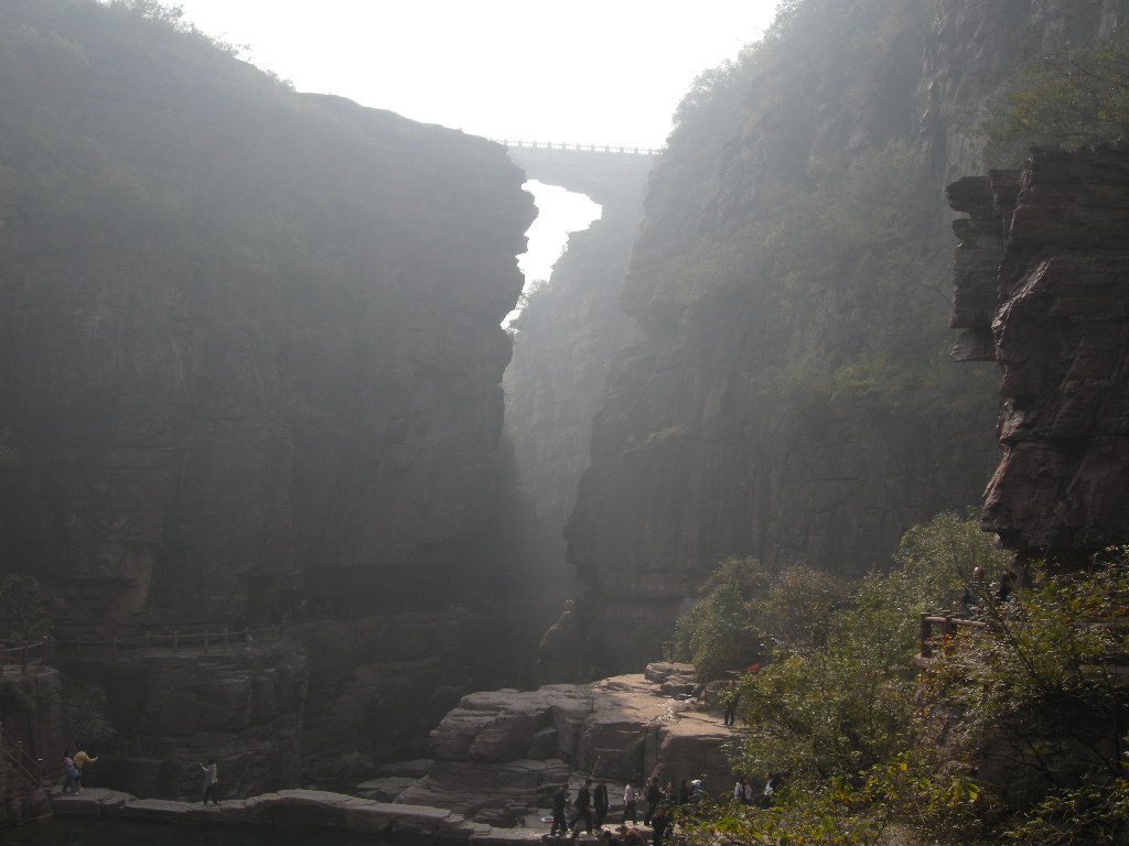 River, bridge over the waterfall and another bridge at the Red Stone Gorge at the Mount Yuntaishan Global Geopark, viewed from the mountainside path