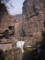 River and waterfall at the Red Stone Gorge at the Mount Yuntaishan Global Geopark, viewed from the mountainside path