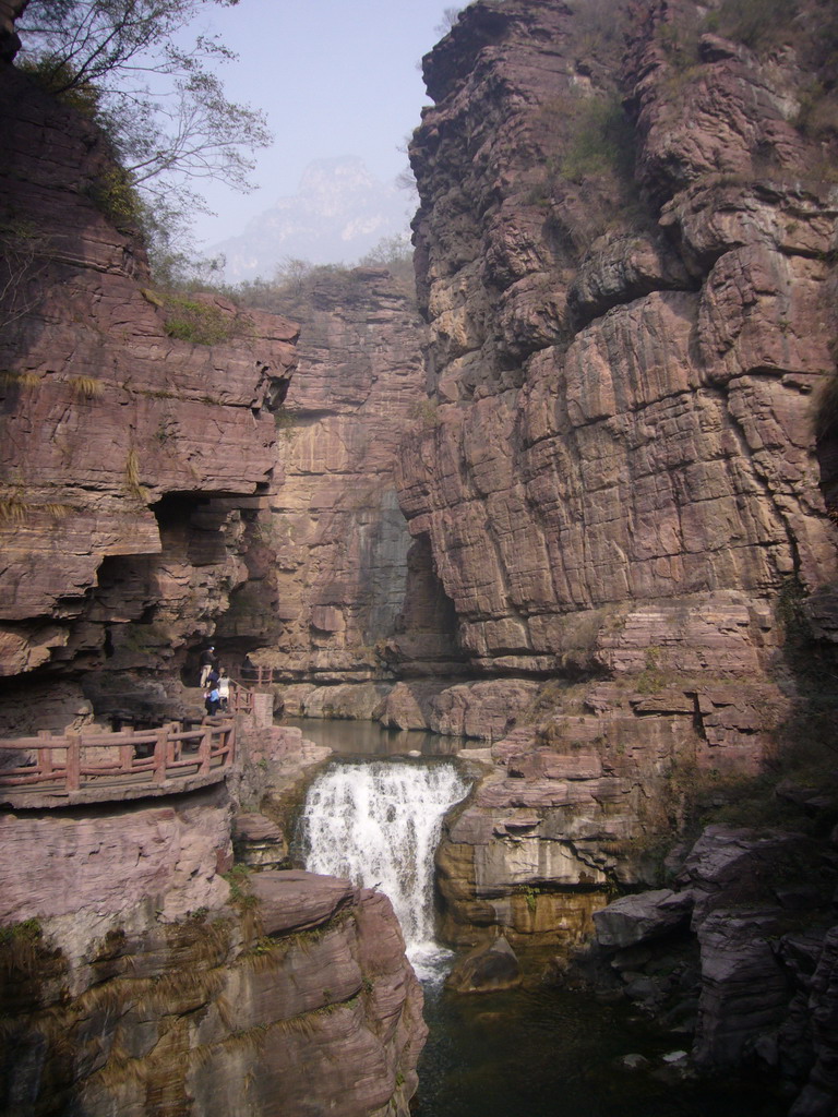 River and waterfall at the Red Stone Gorge at the Mount Yuntaishan Global Geopark, viewed from the mountainside path