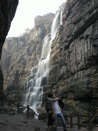 Tim and Miaomiao at the mountainside path at the Red Stone Gorge at the Mount Yuntaishan Global Geopark, with a view on the waterfall