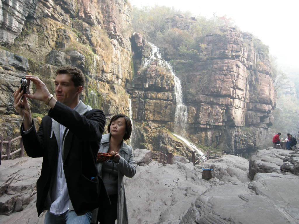 Tim and Miaomiao with waterfalls at the Red Stone Gorge at the Mount Yuntaishan Global Geopark