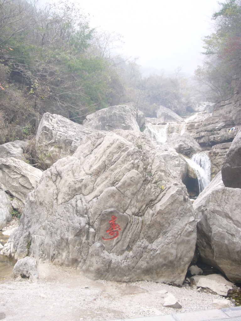 Rock with inscription and waterfall at the Tanpu Gorge at the Mount Yuntaishan Global Geopark