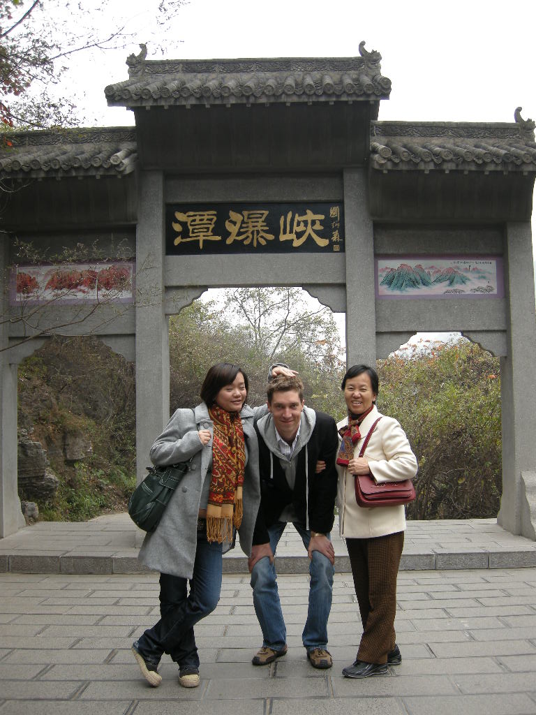 Tim, Miaomiao and Miaomiao`s mother in front of a gate at the Tanpu Gorge at the Mount Yuntaishan Global Geopark