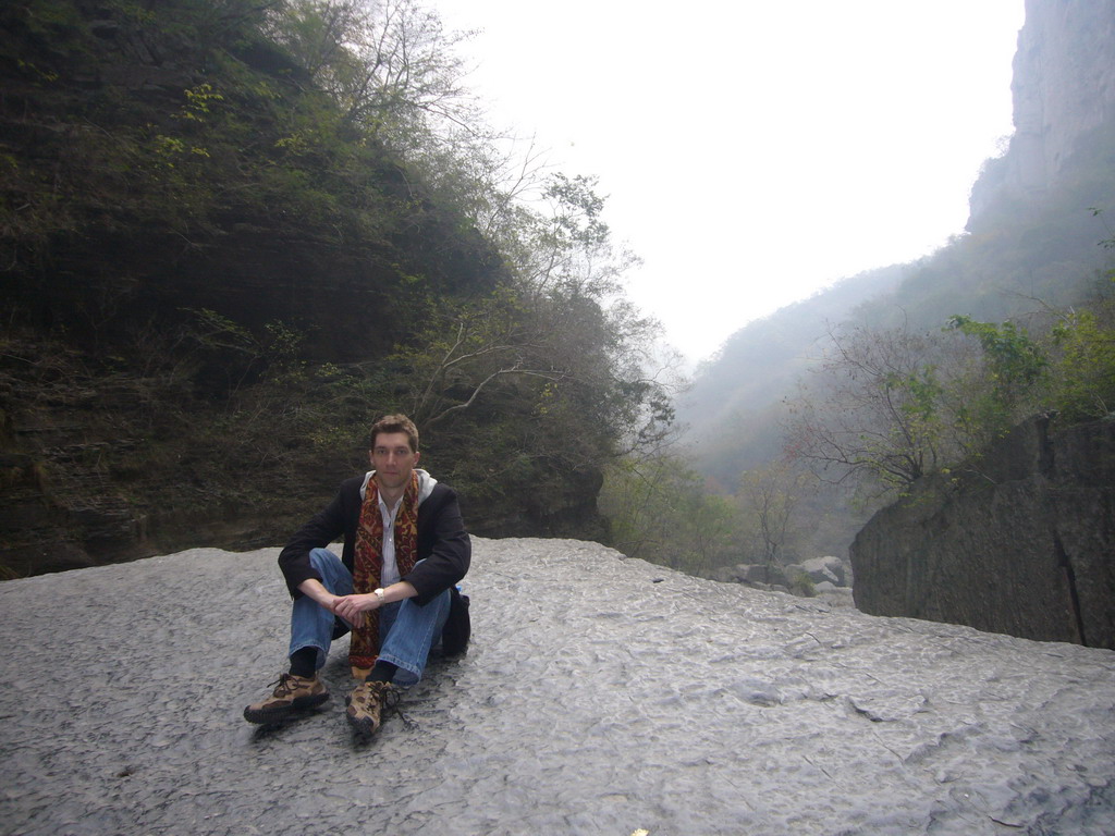 Tim sitting on a rock at the Longfeng Gorge at the Mount Yuntaishan Global Geopark