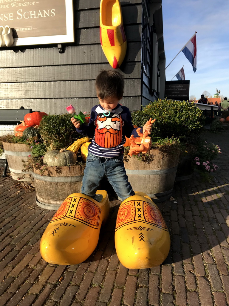 Max with wooden shoes in front of the Wooden Shoe Workshop Zaanse Schans at the Zaanse Schans neighbourhood