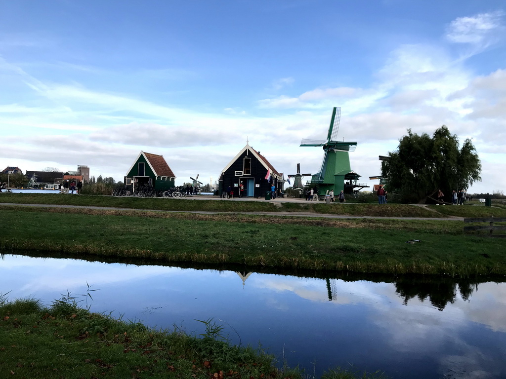 The bike rental shop, the Zaans Gedaan CacaoLab and the Het Jonge Schaap, De Kat and De Gekroonde Poelenburg windmills at the Zaanse Schans neighbourhood, viewed from the Zeilenmakerspad street