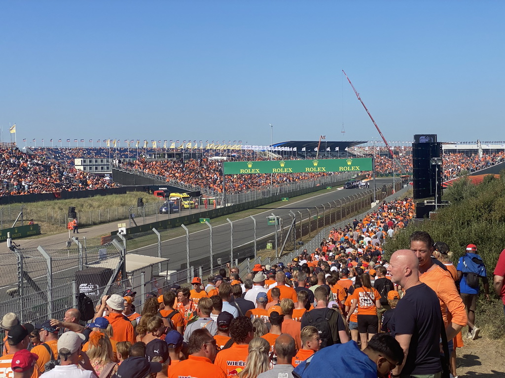 People doing the Paddock Club Tour at the straight between turns 12 and 13 and fans at the Arena-Out Grandstand and Arena Grandstands 2 and 3 at Circuit Zandvoort