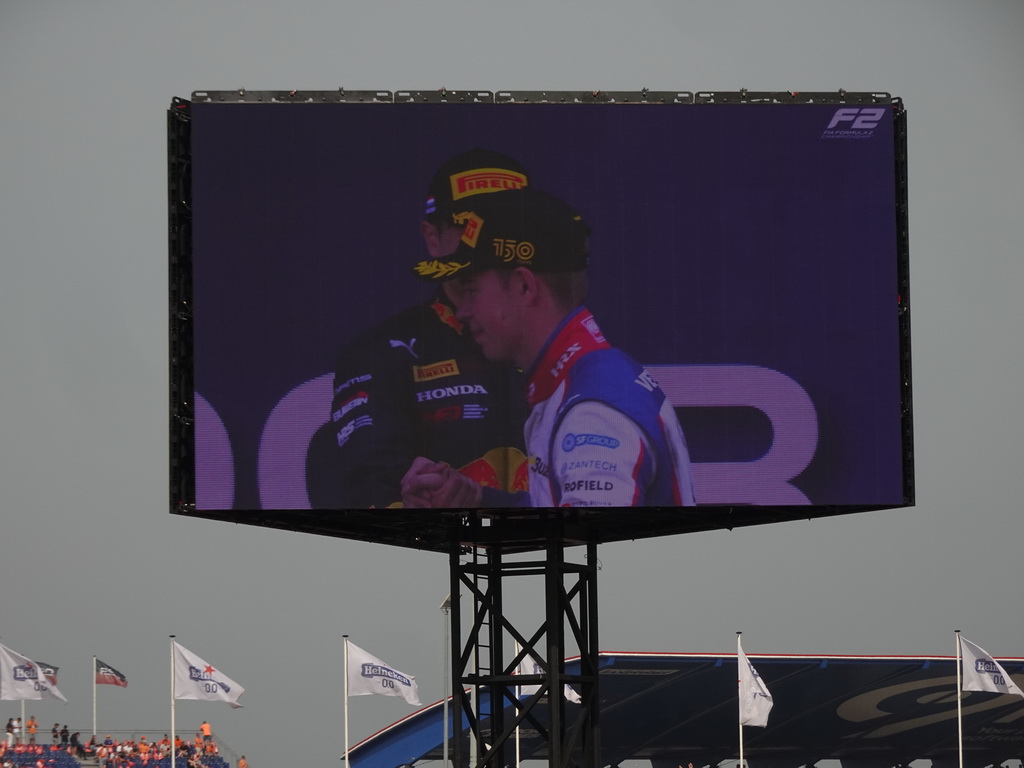 TV screen with Richard Verschoor and Ayumu Iwasa at the main stage at Circuit Zandvoort, viewed from the Eastside Grandstand 3, during the podium ceremony of the Formula 2 Feature Race