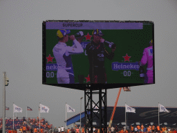 TV screen with Dylan Pereira, Marvin Klein and Larry ten Voorde at the main stage at Circuit Zandvoort, viewed from the Eastside Grandstand 3, during the podium ceremony of the Porsche Mobil 1 Supercup Race