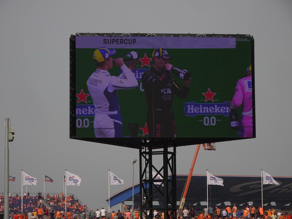 TV screen with Dylan Pereira, Marvin Klein and Larry ten Voorde at the main stage at Circuit Zandvoort, viewed from the Eastside Grandstand 3, during the podium ceremony of the Porsche Mobil 1 Supercup Race