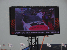 TV Screen with Lewis Hamilton getting into the car for the Formula 1 Drivers` Parade at the main straight at Circuit Zandvoort, viewed from the Eastside Grandstand 3