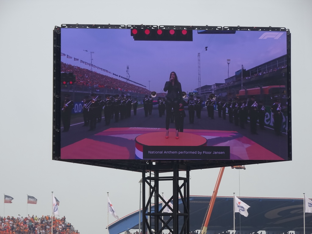 TV screen with Floor Jansen and orchestra performing the Dutch National Anthem at the main straight at Circuit Zandvoort, viewed from the Eastside Grandstand 3, during the pre-race show of the Formula 1 Race