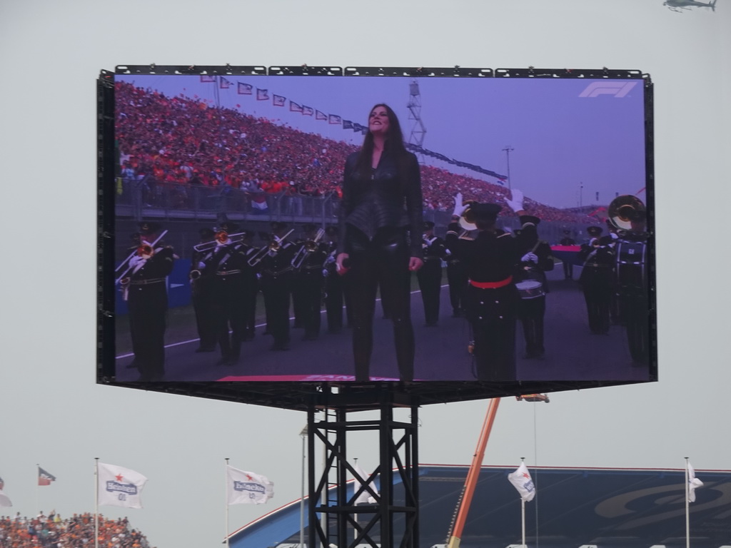 TV screen with Floor Jansen and orchestra performing the Dutch National Anthem at the main straight at Circuit Zandvoort, viewed from the Eastside Grandstand 3, during the pre-race show of the Formula 1 Race