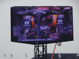 TV screen with Max Verstappen in his Formula 1 car at the main straight at Circuit Zandvoort, viewed from the Eastside Grandstand 3, just before the Formula 1 Race