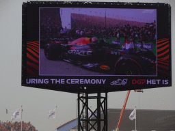 TV screen with Max Verstappen in his Formula 1 car at the pit straight at Circuit Zandvoort, viewed from the Eastside Grandstand 3, right after the Formula 1 Race