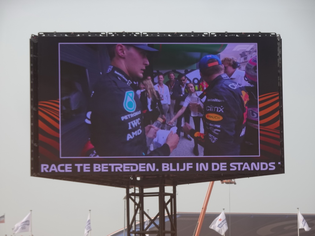 TV screen with Max Verstappen and George Russell at the pit straight at Circuit Zandvoort, viewed from the Eastside Grandstand 3, right after the Formula 1 Race
