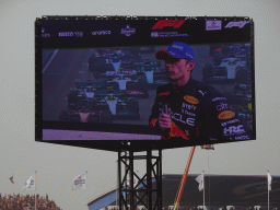 TV screen with Max Verstappen being interviewed at the pit straight at Circuit Zandvoort, viewed from the Eastside Grandstand 3, right after the Formula 1 Race