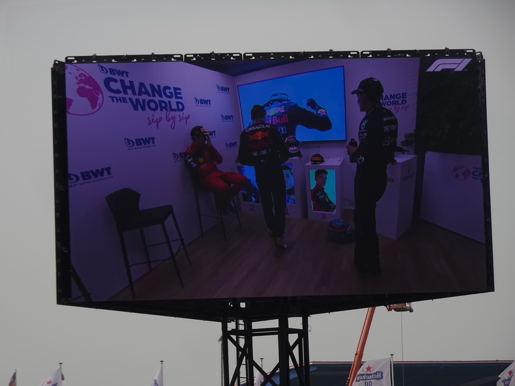 TV screen with Charles Leclerc, Max Verstappen and George Russell at the paddock at Circuit Zandvoort, viewed from the Eastside Grandstand 3, right after the Formula 1 Race