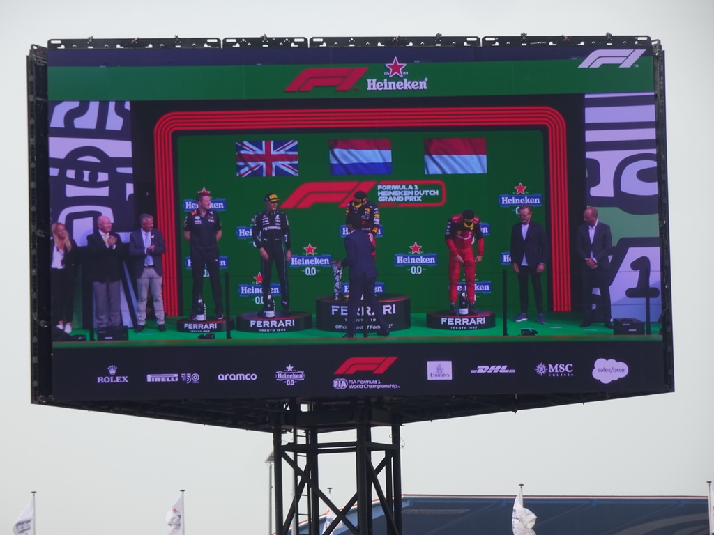 TV screen with George Russell, Max Verstappen and Charles Leclerc at the main stage at Circuit Zandvoort, viewed from the Eastside Grandstand 3, during the podium ceremony of the Formula 1 Race