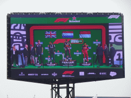 TV screen with George Russell, Max Verstappen and Charles Leclerc at the main stage at Circuit Zandvoort, viewed from the Eastside Grandstand 3, during the podium ceremony of the Formula 1 Race