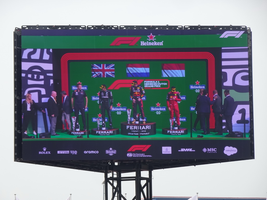 TV screen with George Russell, Max Verstappen and Charles Leclerc at the main stage at Circuit Zandvoort, viewed from the Eastside Grandstand 3, during the podium ceremony of the Formula 1 Race