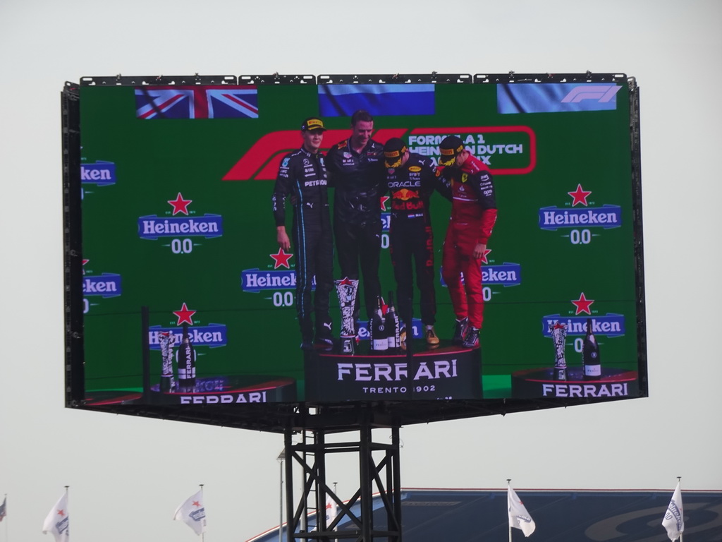 TV screen with George Russell, Max Verstappen and Charles Leclerc at the main stage at Circuit Zandvoort, viewed from the Eastside Grandstand 3, during the podium ceremony of the Formula 1 Race